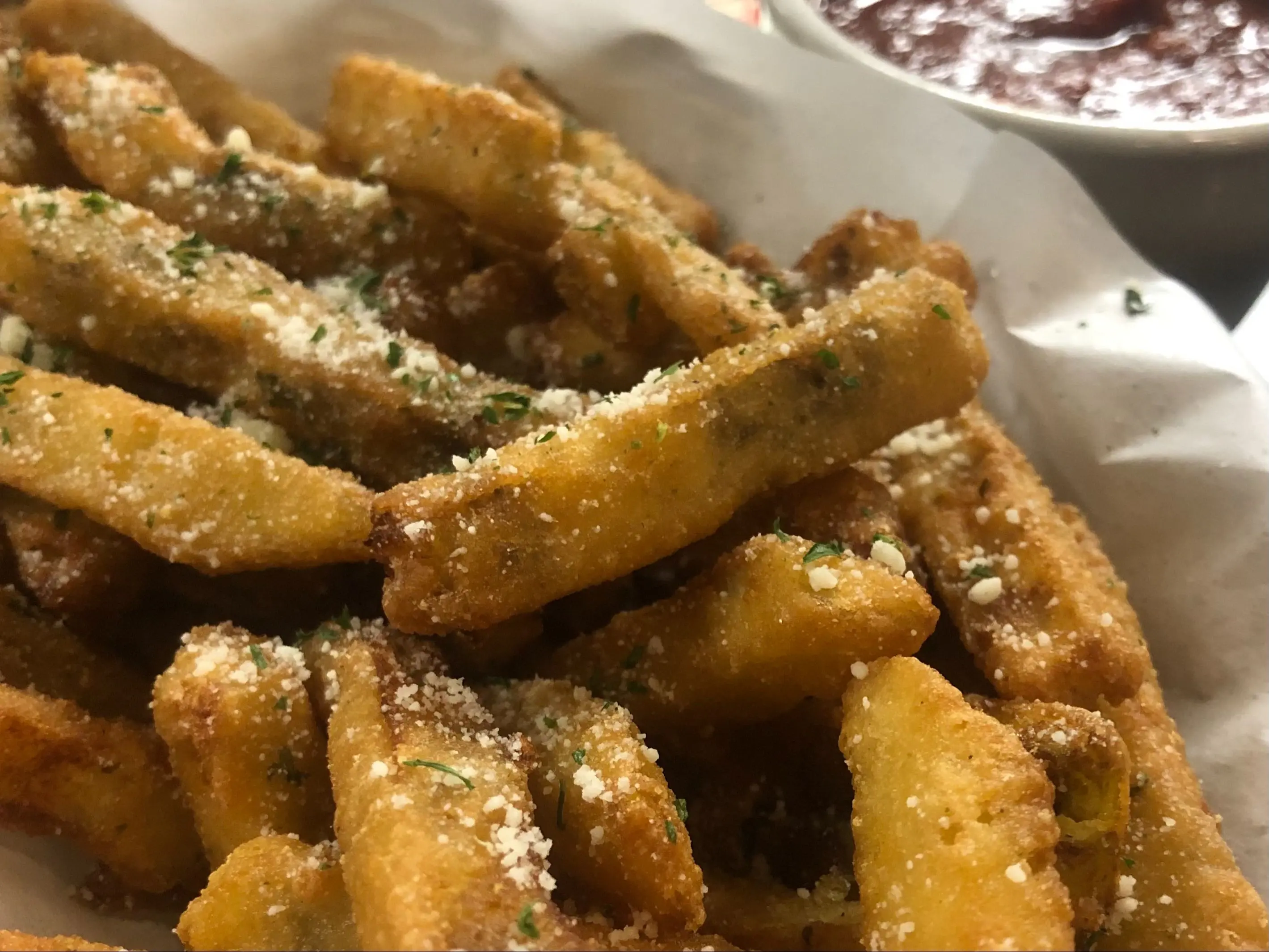 Eggplant fries dusted with seasoning, served with a cup of homemade marinara